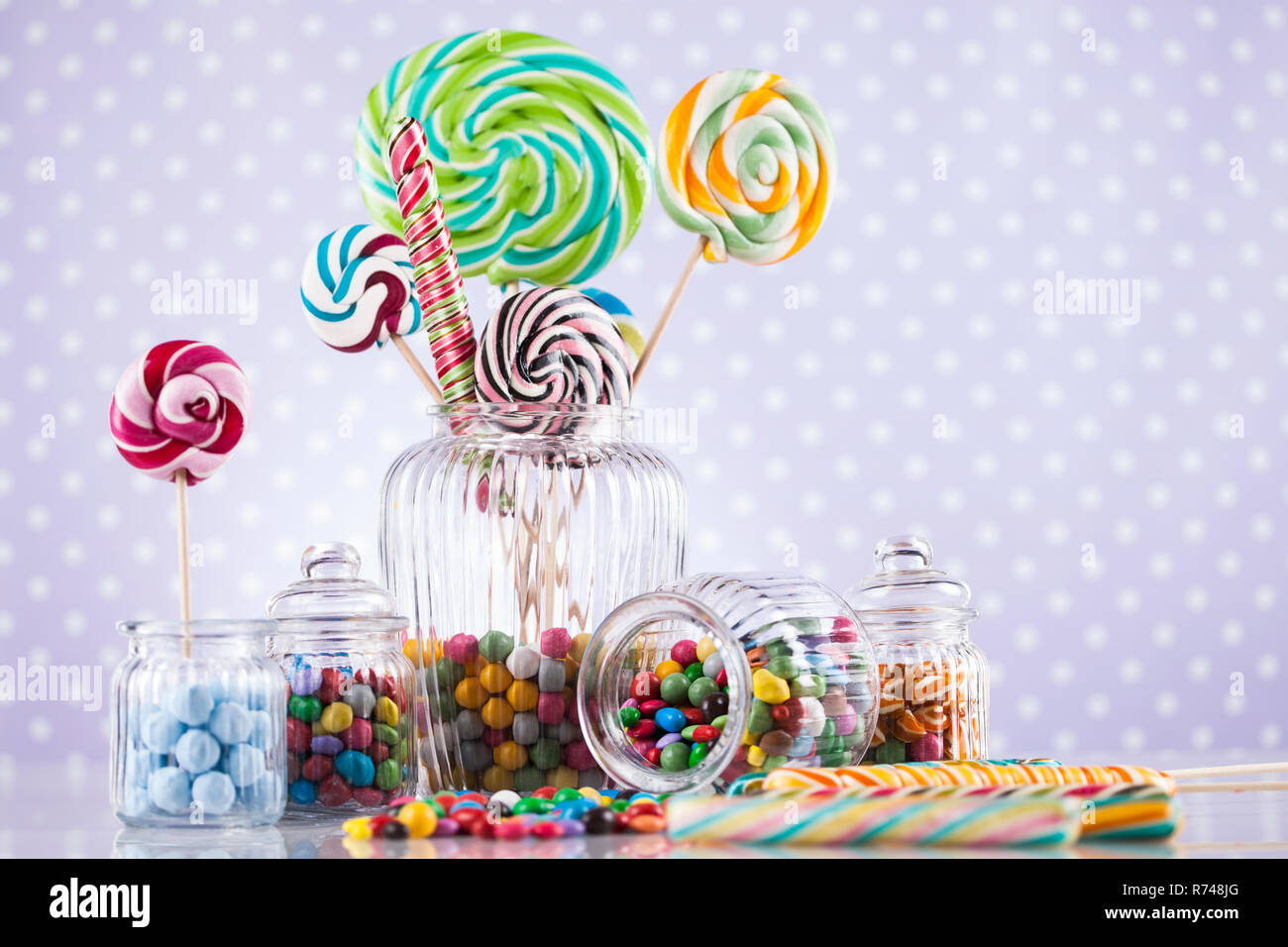 Colorful lollipops and different colored round candy and gum balls ...