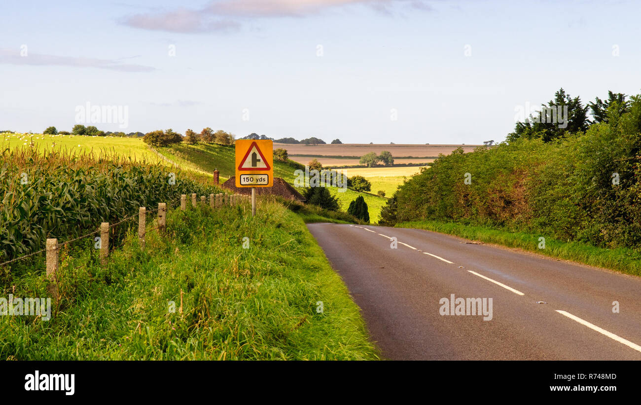 A country road rolls across hills and valleys of farmland fields between Sherborne and Wincanton on the Somerset/Dorset border. Stock Photo
