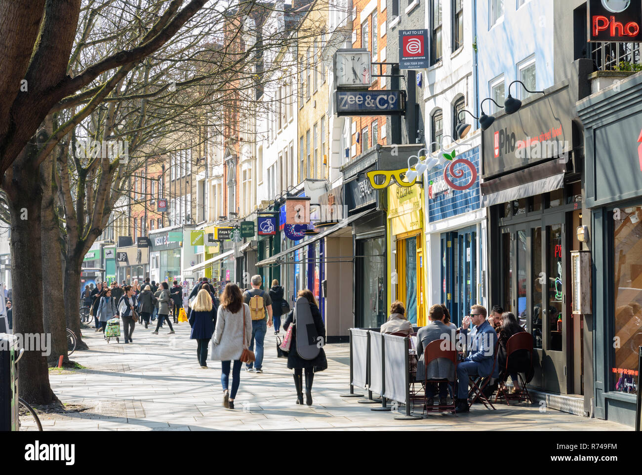 London, England, UK - March 27, 2017: Pedestrians and shoppers walk past traditional high street shops on Upper Street in Islington Angel, North Londo Stock Photo