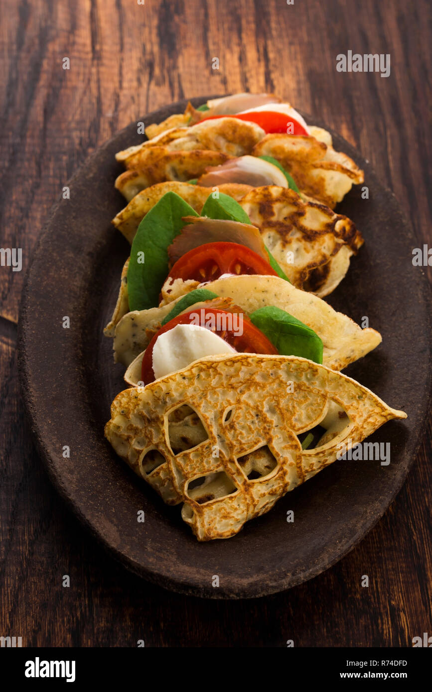Pancakes sutffed with ham, cheese, tomatoes and spinach Stock Photo
