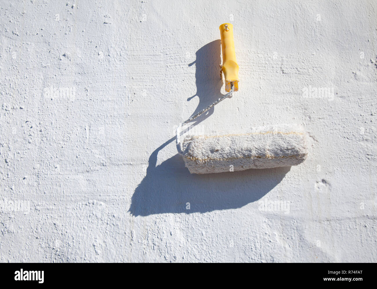 whitewashed exterior wall with paintroller simple rustic background Stock Photo