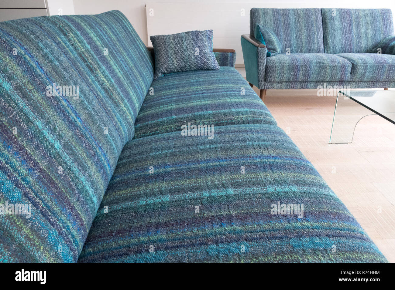Two retro style lounge sofas upholstered in blue / green striped wool