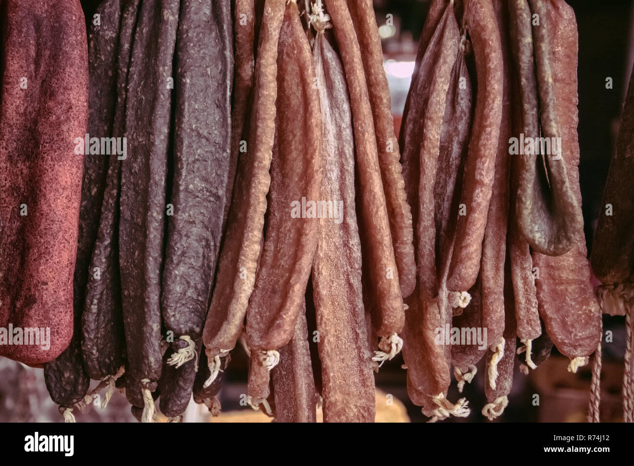 Sujuk and beef jerky hangs on a counter in the street market in the evening Stock Photo