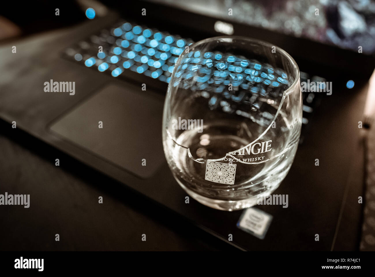 Shattered whisky glass on a laptop Stock Photo