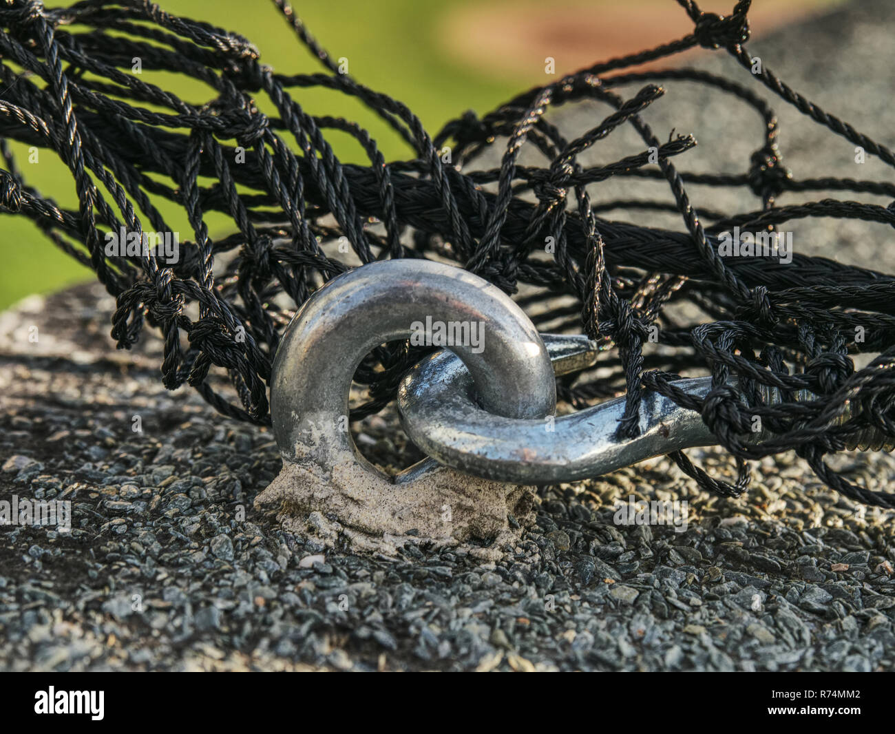 Steel twisted rope and steel bolt anchor eye in concrete base. The end
