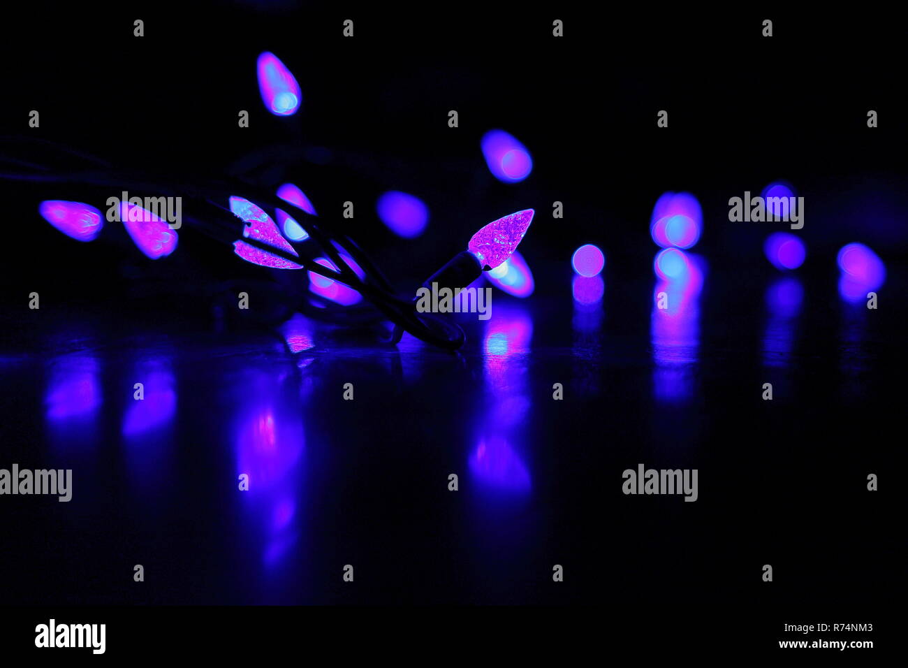 Purple holiday lights reflected onto floor Stock Photo