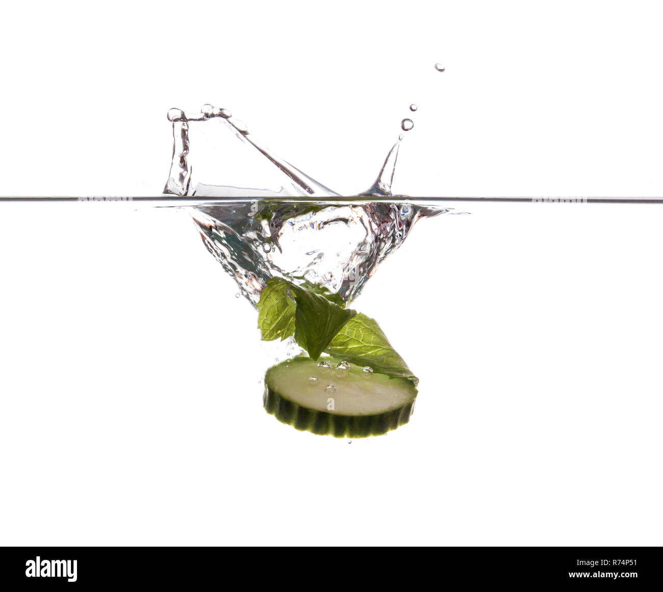 Cucumber slice and mint sinking underwater Stock Photo