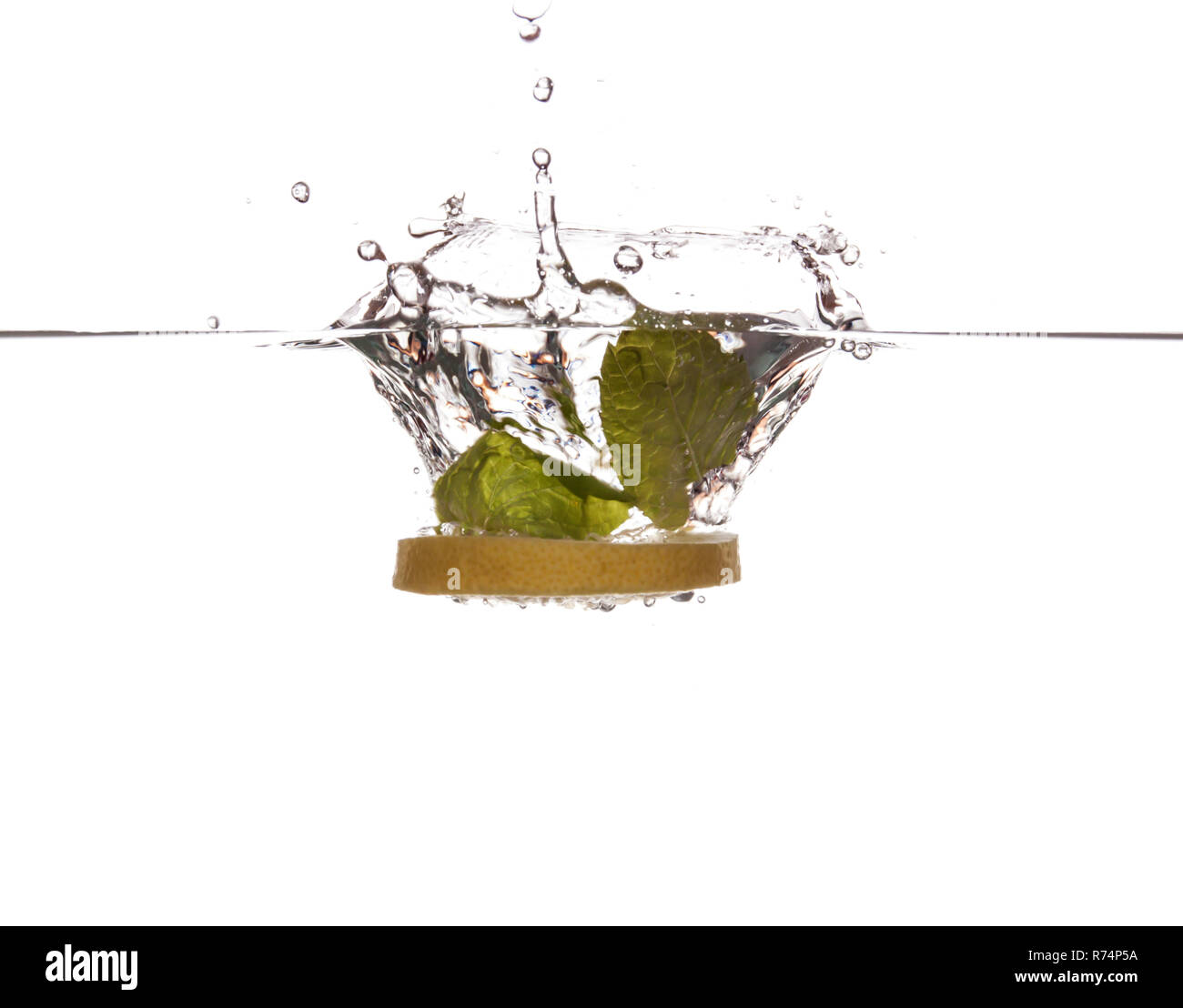 Lemon slice and mint sinking underwater Stock Photo