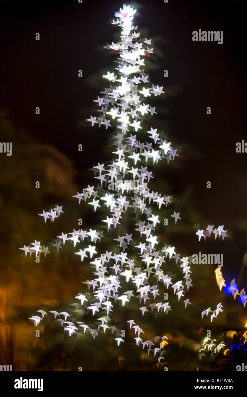 Defocused christmas tree lights. Star shaped bokeh Stock Photo
