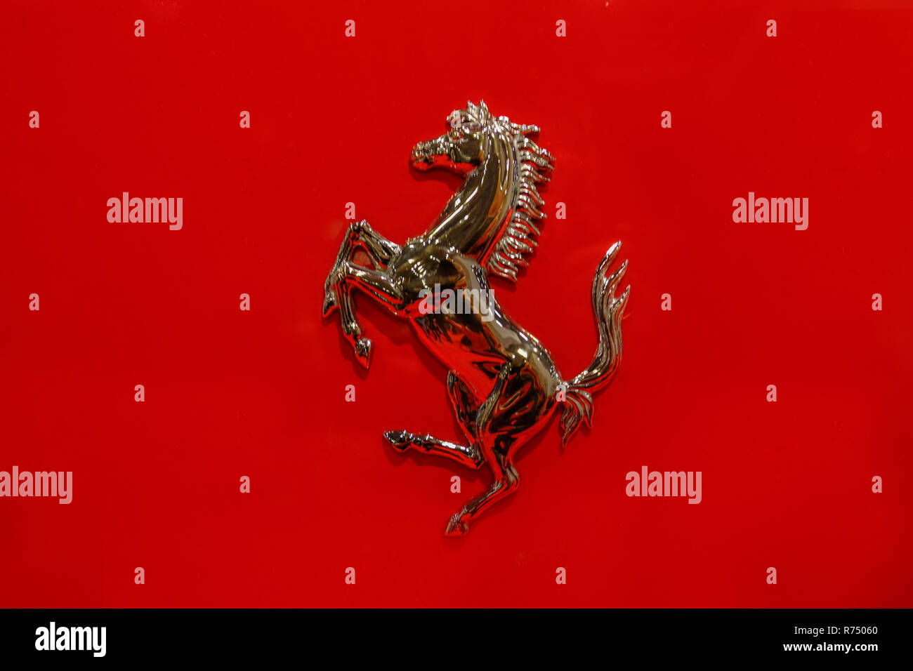 London, UK - February 16, 2018: Closeup of horse rearing up on a red background.  Ferarri iconic car symbol. Stock Photo