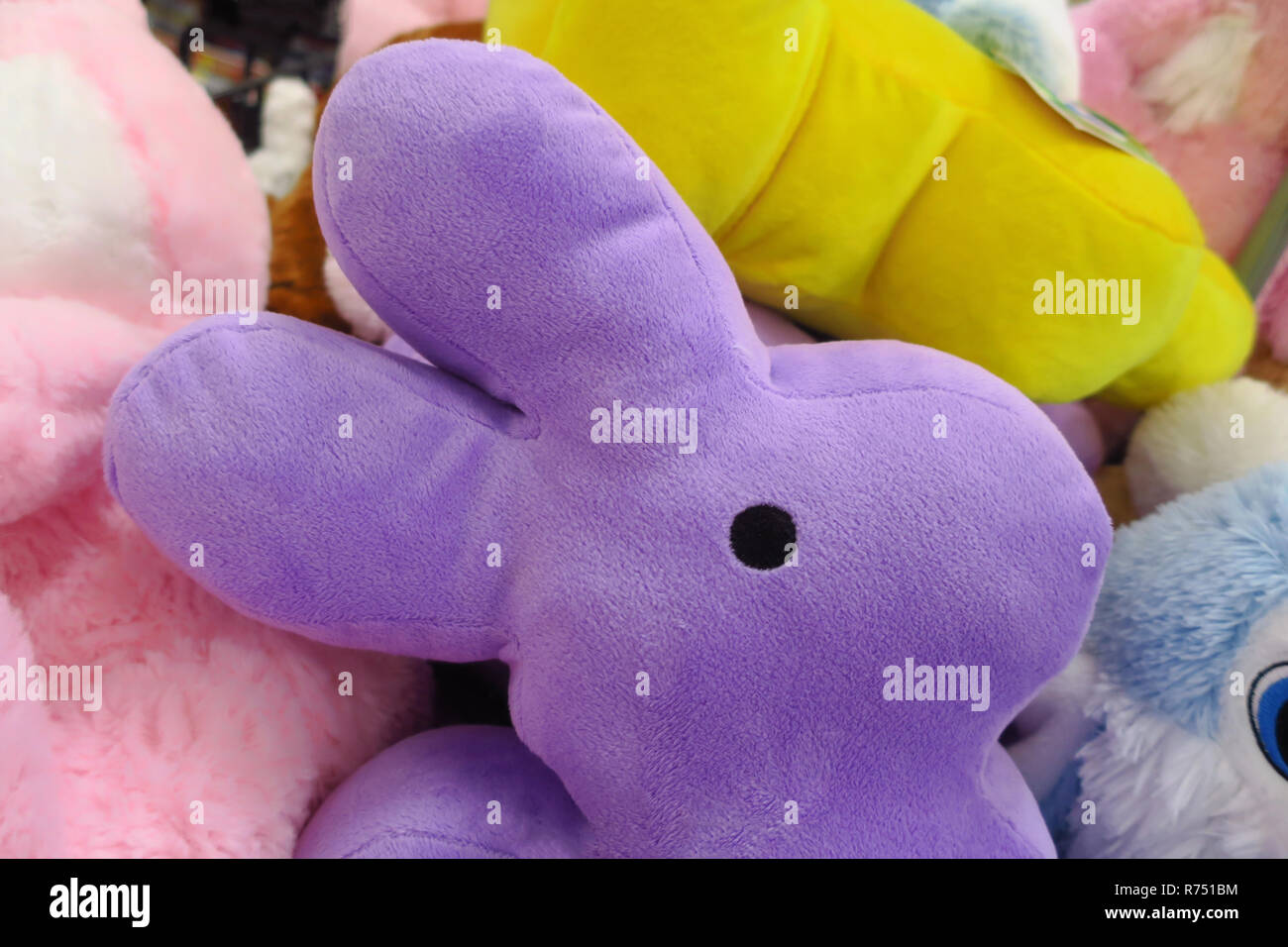 A stuffed purple bunny in a group of stuffed animals. Stock Photo