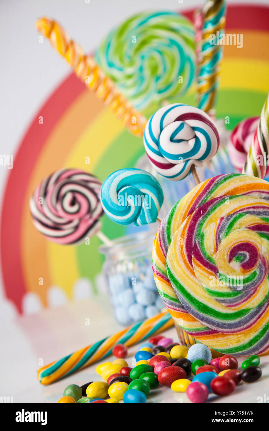 Colorful lollipops and different colored round candy and gum balls ...