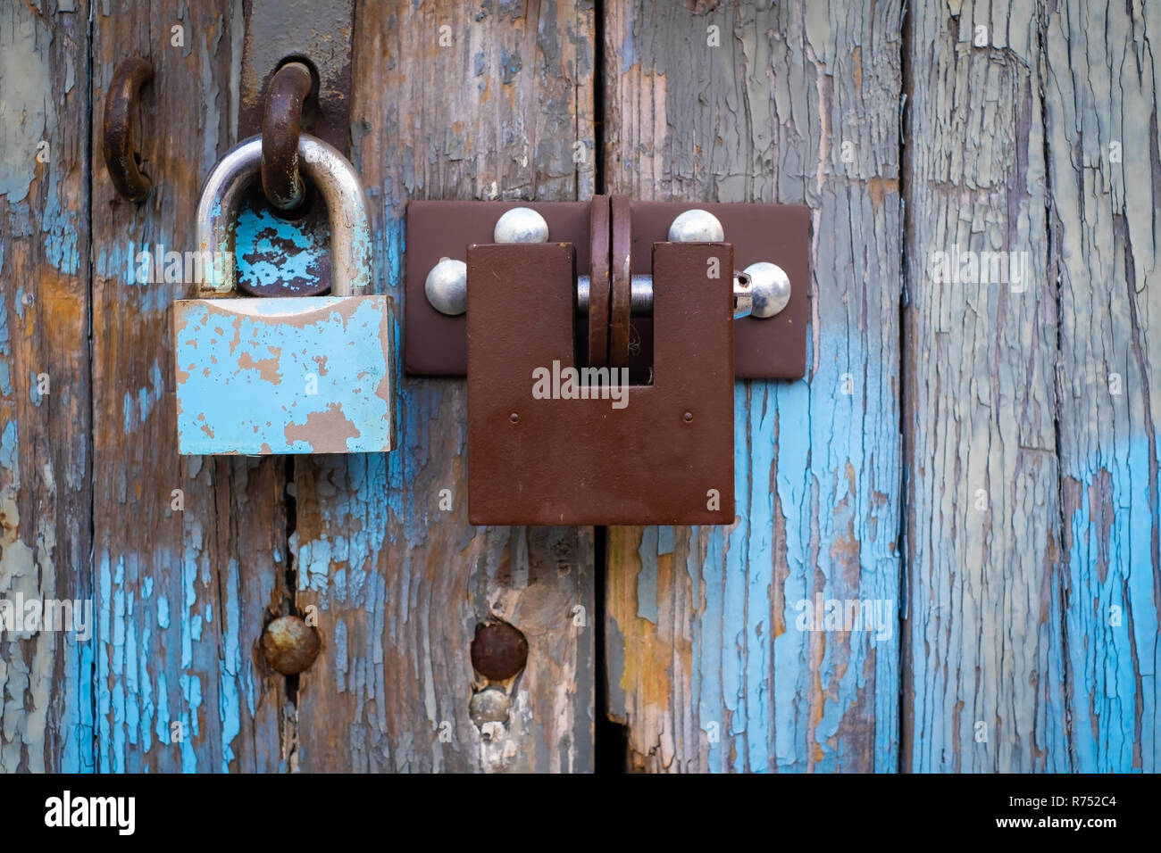 two locks on old vintage wooden garage door, peeling paint Stock Photo