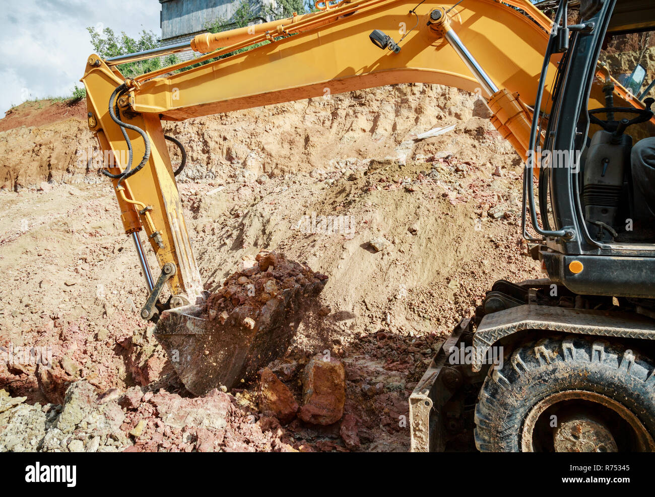 Excavator digging a hole. Work on the construction site Stock Photo - Alamy