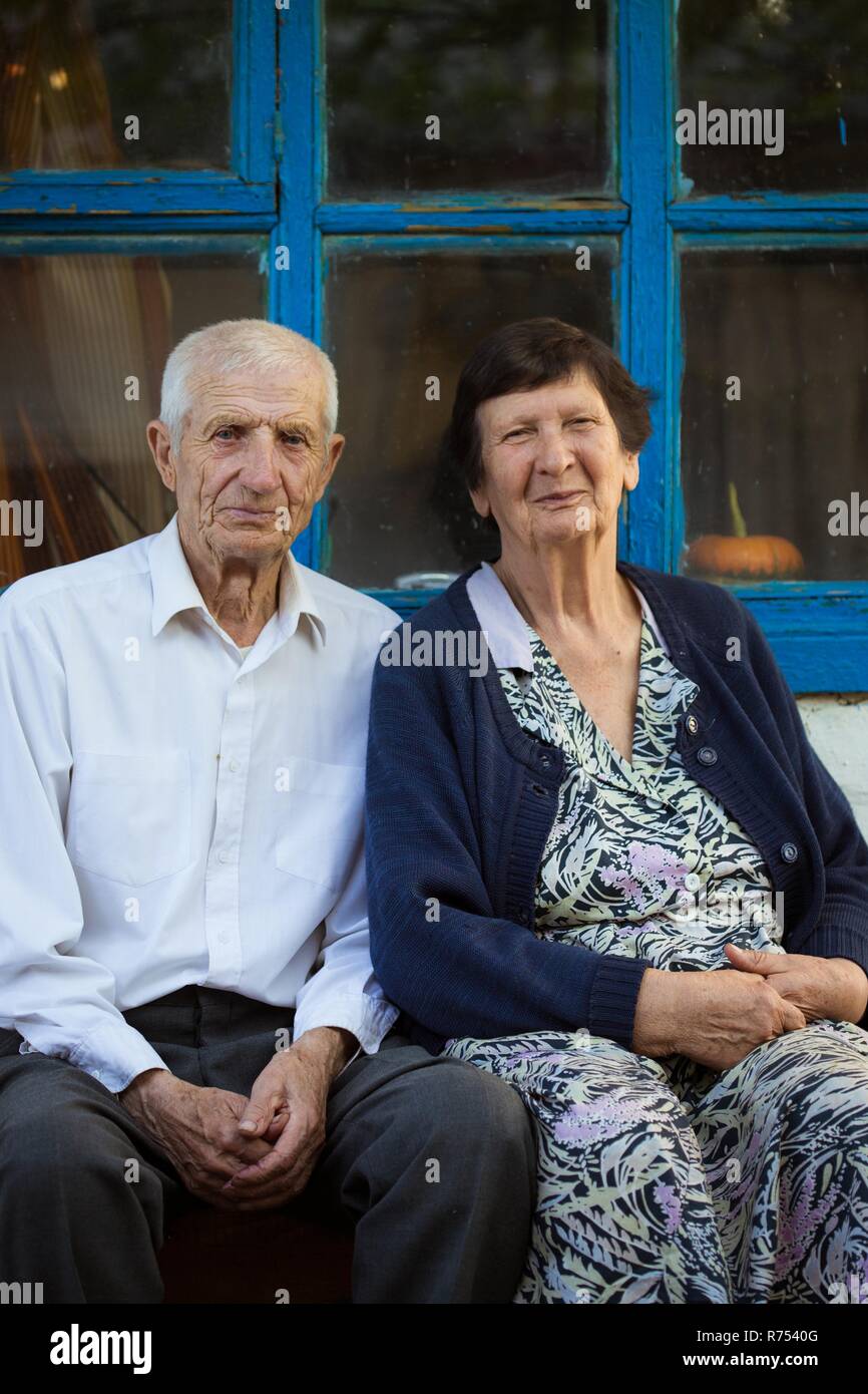 Elderly couple sitting at the front of rural house Stock Photo - Alamy