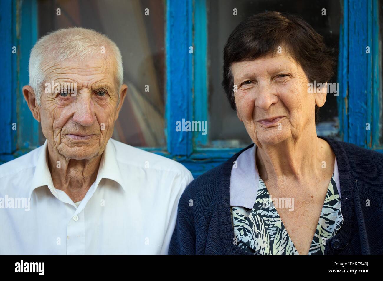 Elderly couple sitting at the front of rural house Stock Photo - Alamy
