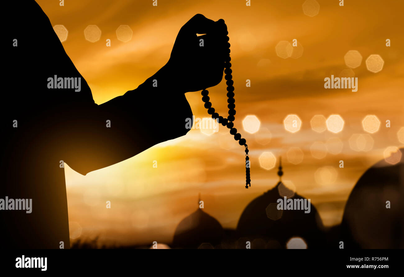 Silhouette of muslim man praying with prayer beads Stock Photo - Alamy