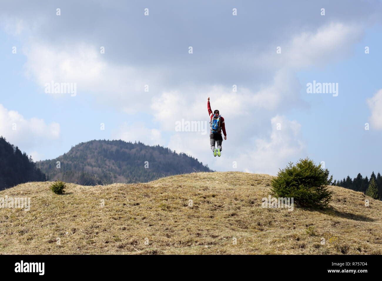 hiker jumps in the air for joy Stock Photo