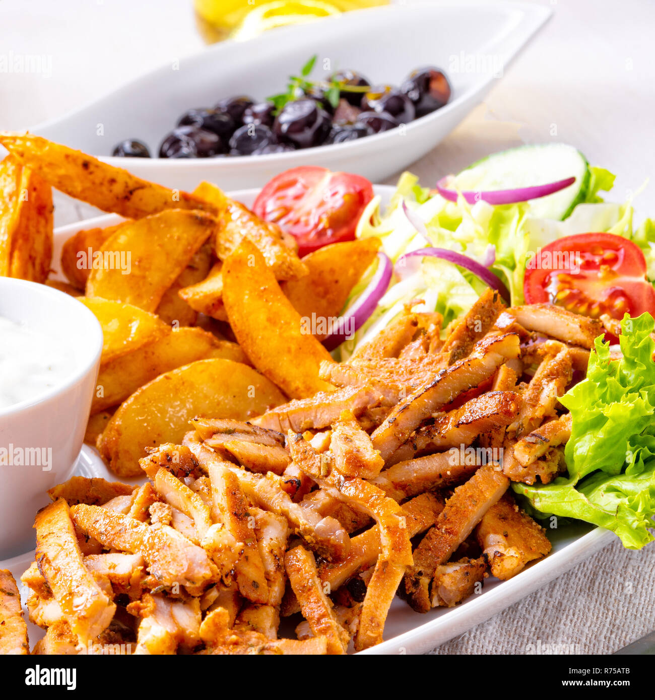 gyros plate with green salad,olives and potato wedges Stock Photo Alamy