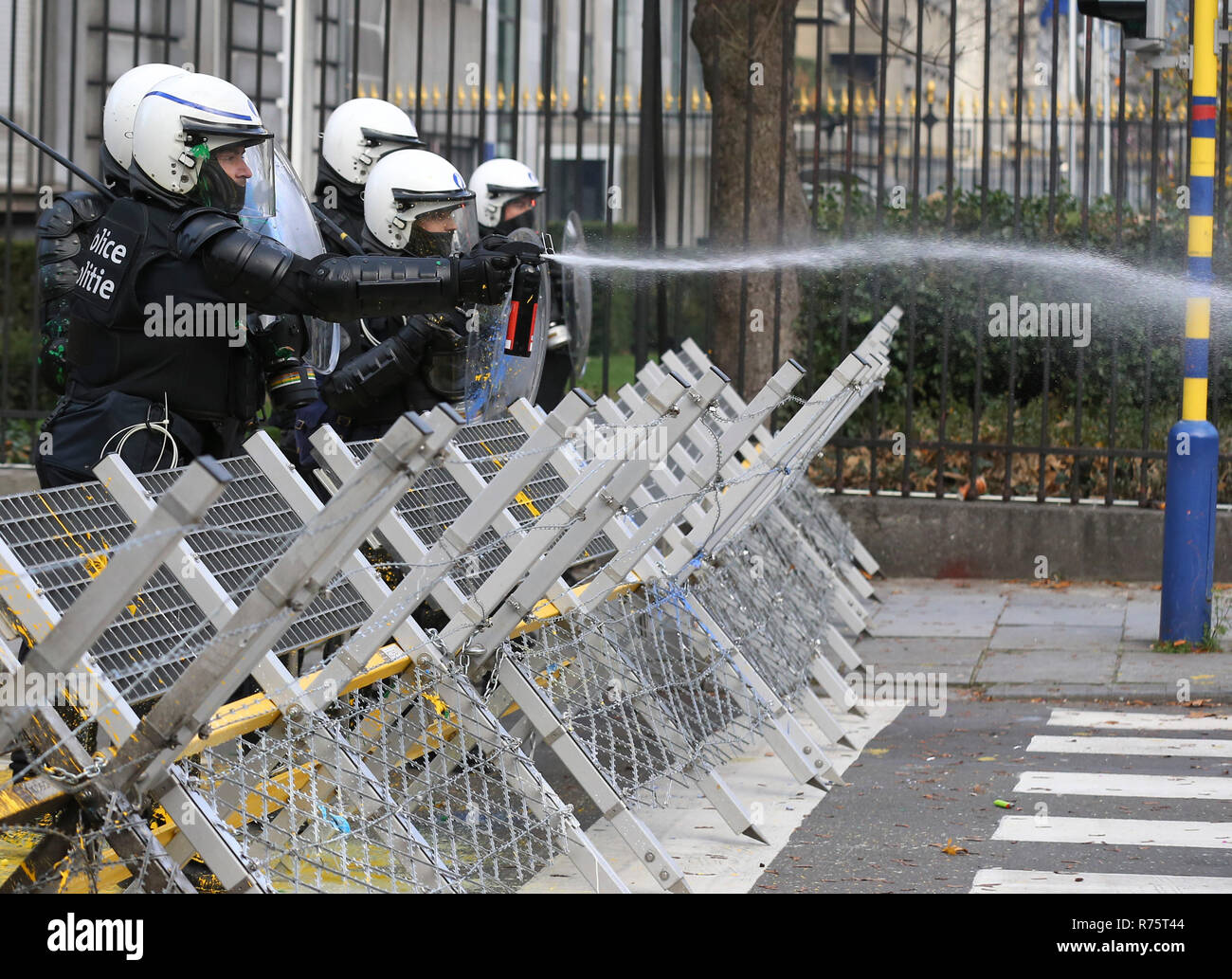 Brussels, Belgium. 8th Dec, 2018. A Police officer squirts pepper water to a protester of the 'Yellow Vests' during a demonstration in downtown Brussels, Belgium, Dec. 8, 2018. Credit: Ye Pingfan/Xinhua/Alamy Live News Stock Photo