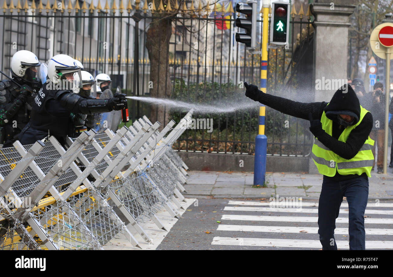 Brussels, Belgium. 8th Dec, 2018. A Police officer squirts pepper water to a protester of the 'Yellow Vests' during a demonstration in downtown Brussels, Belgium, Dec. 8, 2018. Credit: Ye Pingfan/Xinhua/Alamy Live News Stock Photo