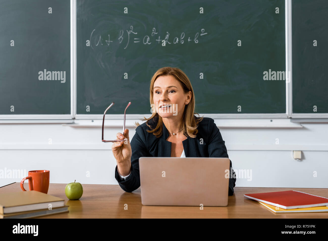 Attractive teacher sitting desk hi-res stock photography and images - Alamy