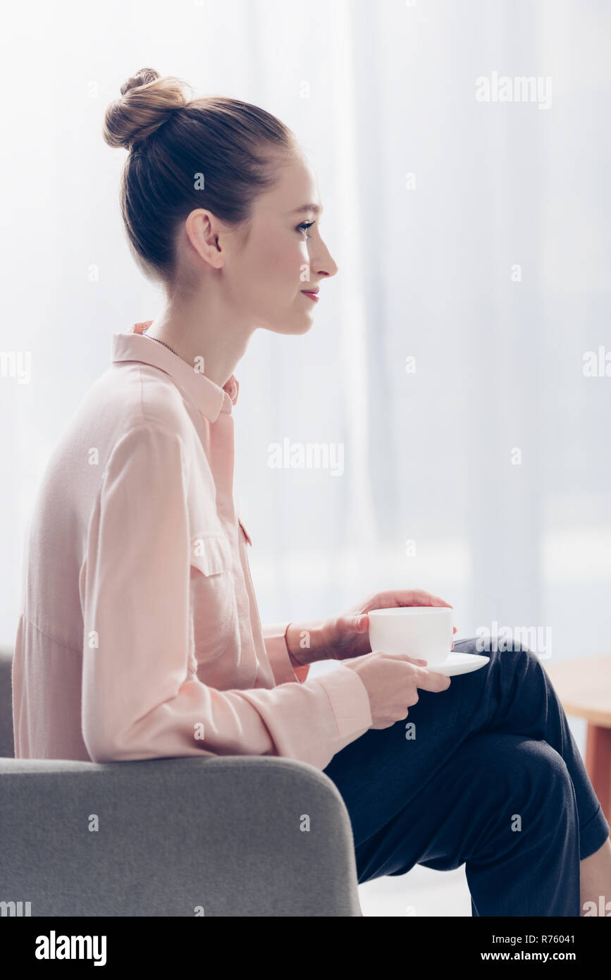 Side View Of Cheerful Beautiful Businesswoman Sitting With Cup Of Tea In Armchair In Office Stock Photo Alamy