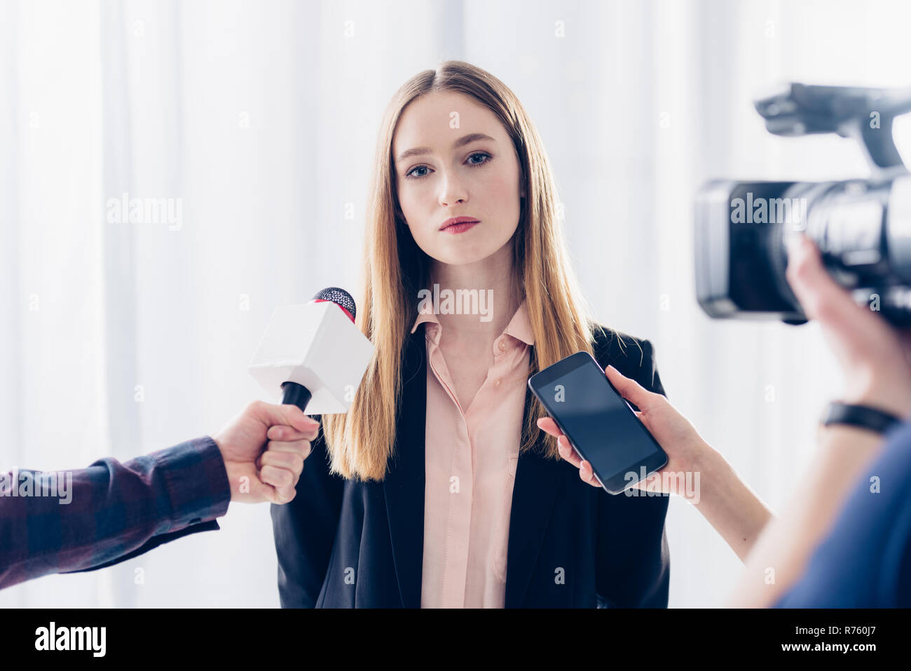 attractive businesswoman giving interview to journalists in office Stock Photo