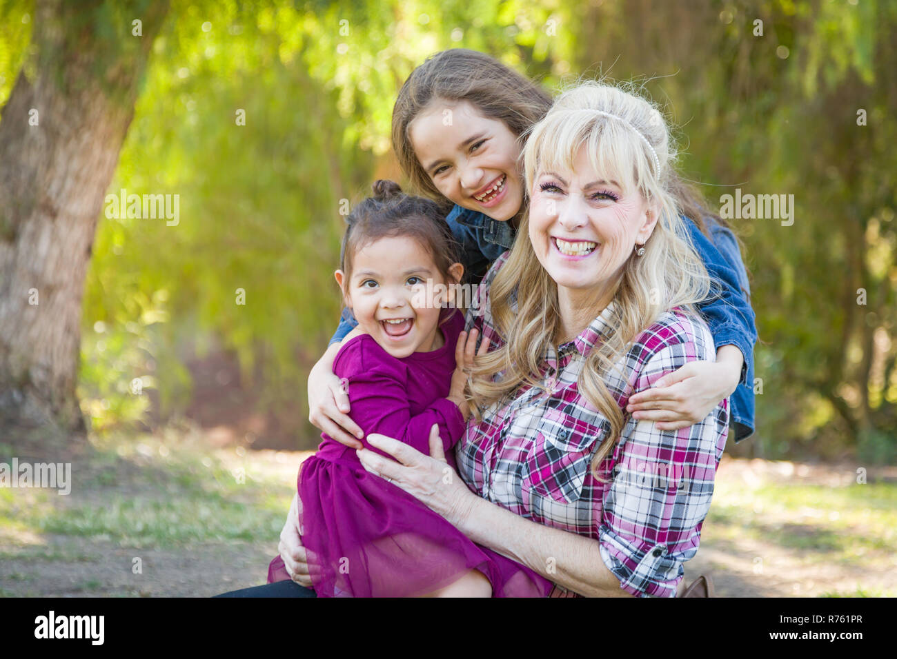 Caucasian Grandmother With Young Mixed Race Grandaughters Outdoors. Stock Photo