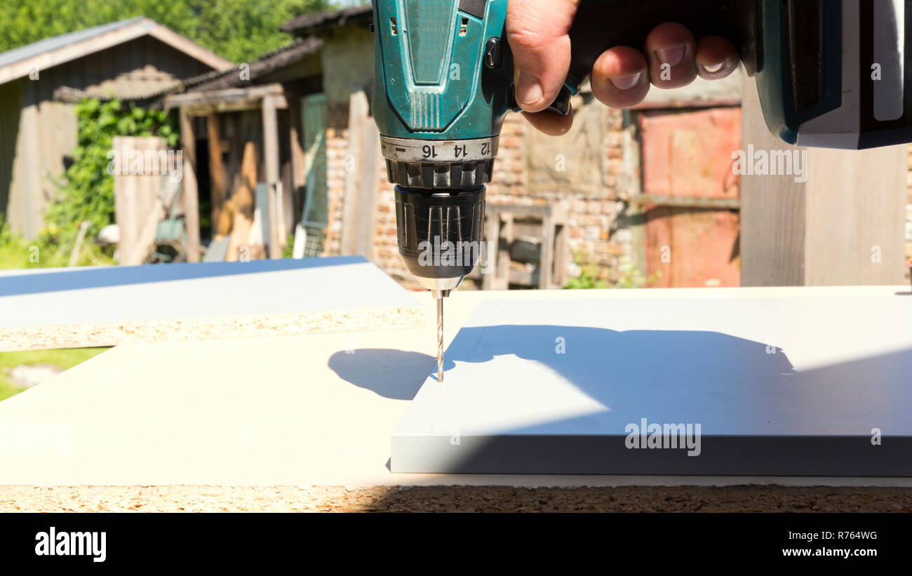 Furniture assembly. Making of kitchen using screwdriver, construction clamp and screws