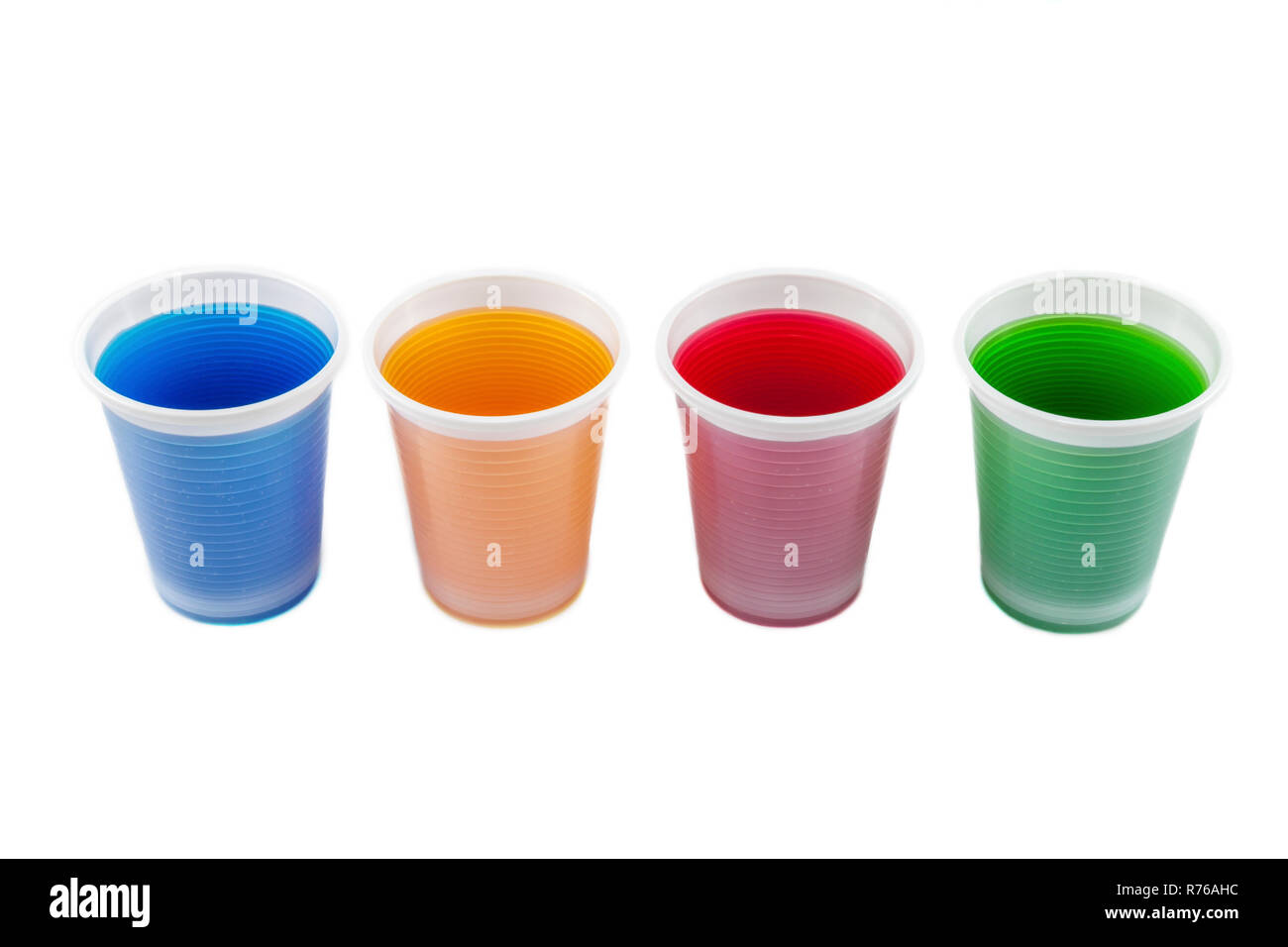 Plastic cups filled in with different collored water. Stock Photo