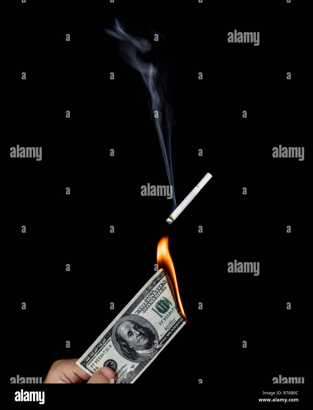 Human hand holding a burning 100 dollar bill and lighting a cigarette Stock Photo Alamy