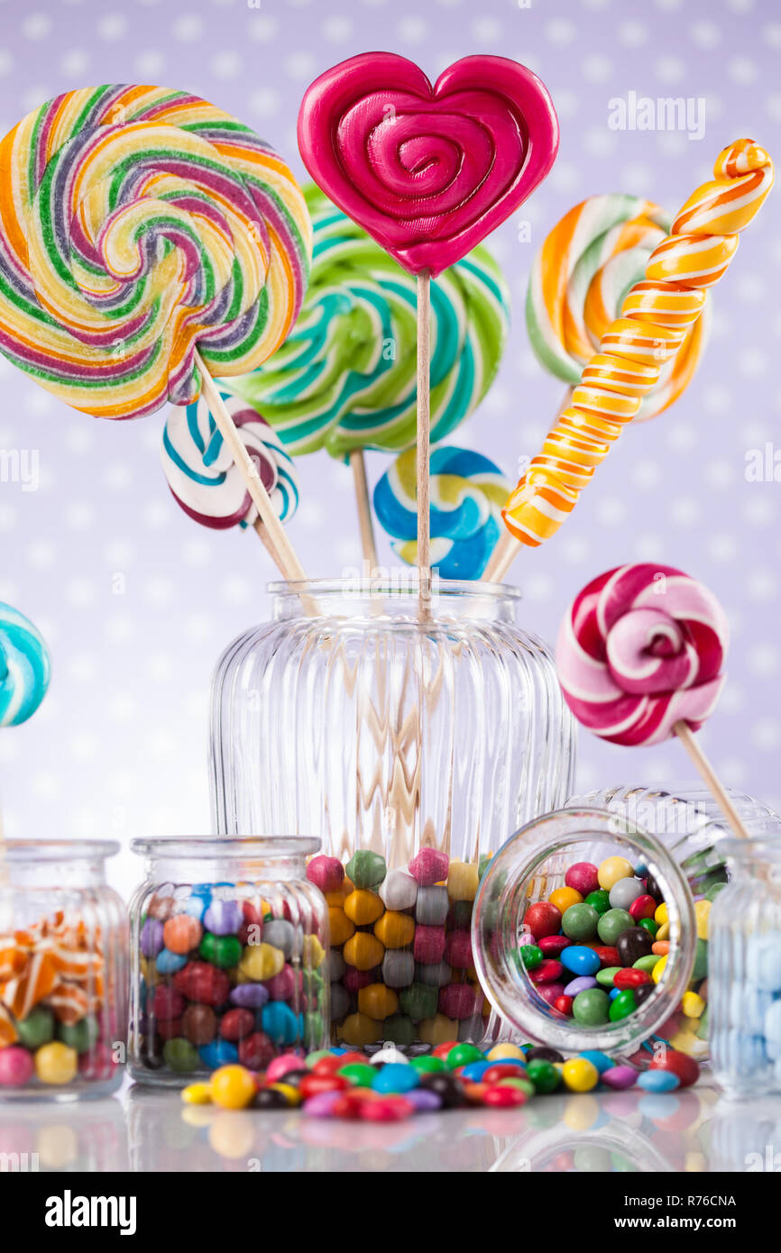 Colorful lollipops and different colored round candy and gum balls ...