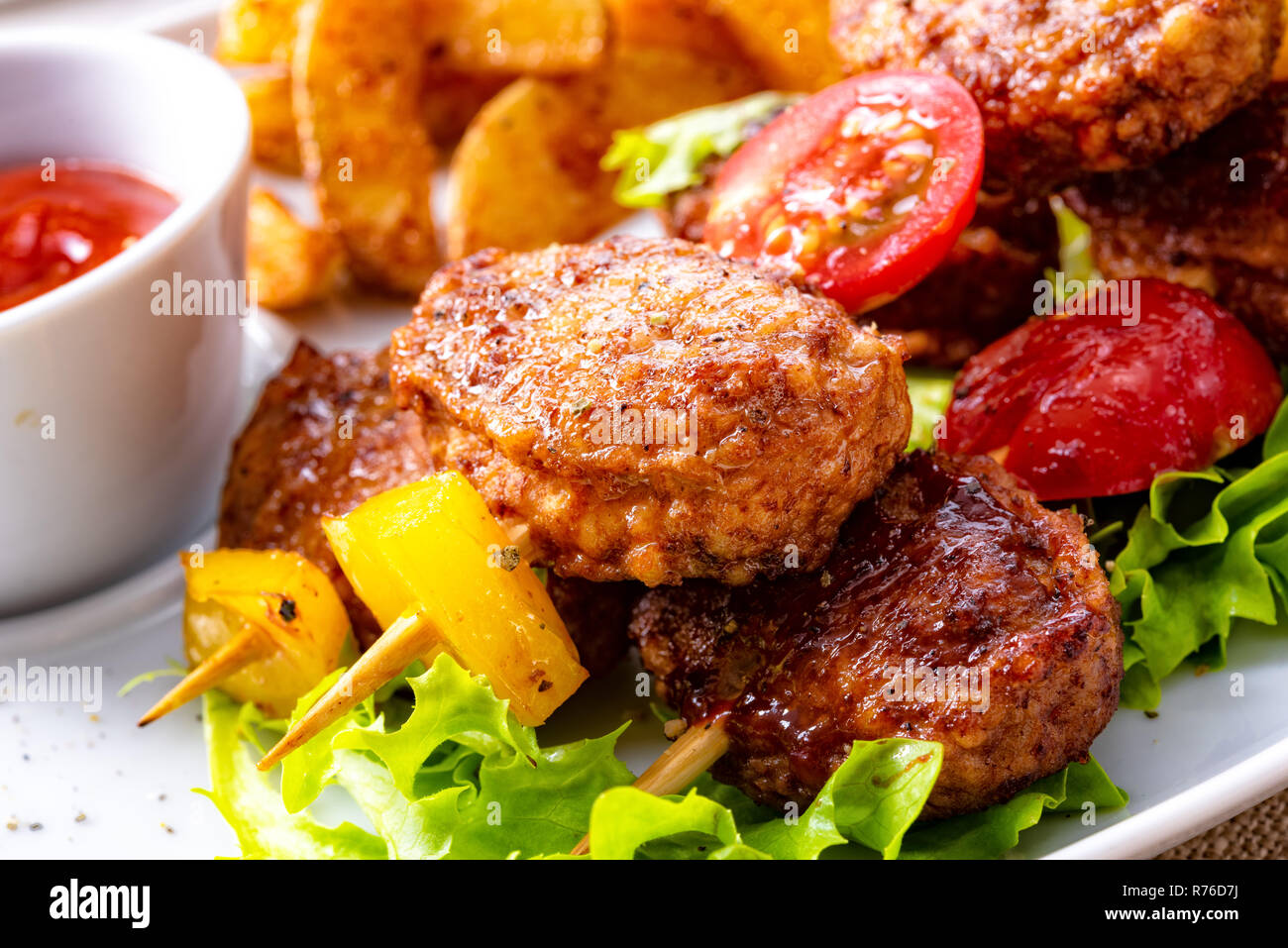 meatballs skewers of tomato,paprika and baked potato quarters Stock Photo