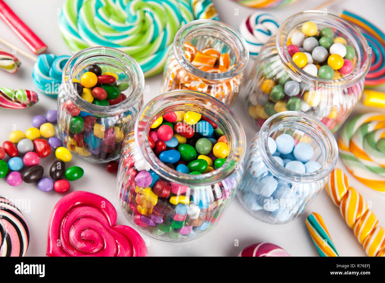 Colorful lollipops and different colored round candy and gum balls ...