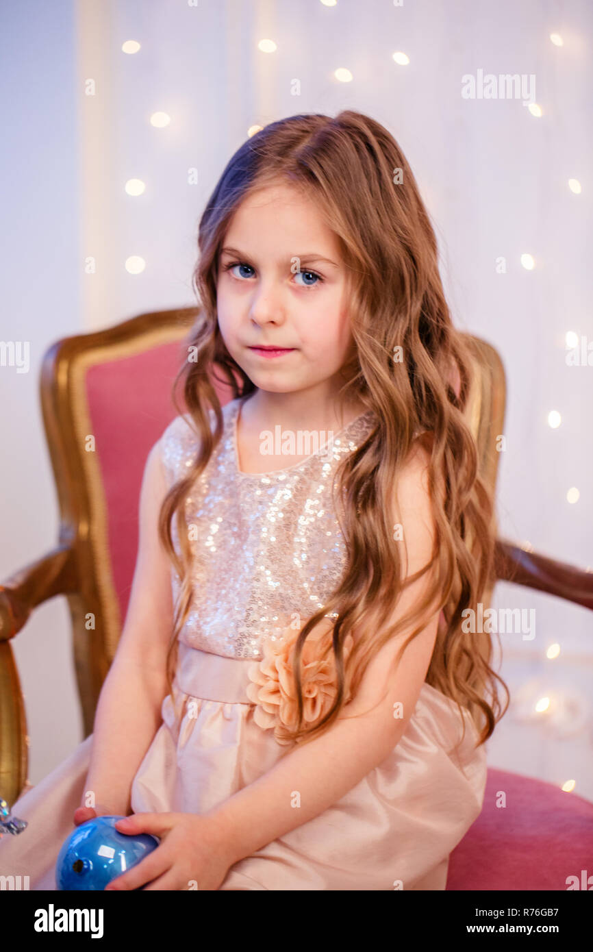 Portrait Of A Little Girl With Curly Hair On Christmas Eve The