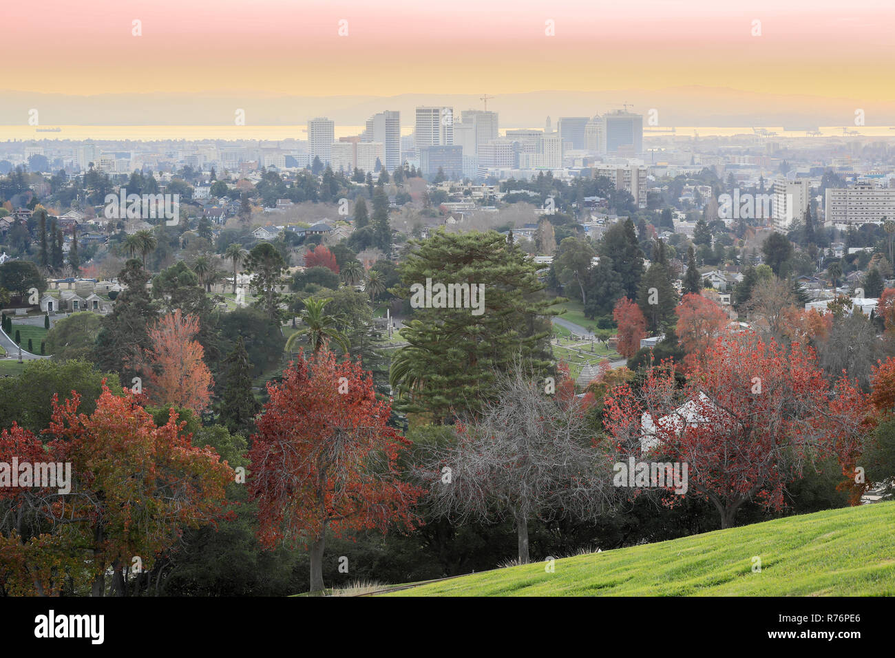 Sunset views of Oakland Downtown and San Francisco Bay from a hilltop in Mountain View Cemetery. Stock Photo