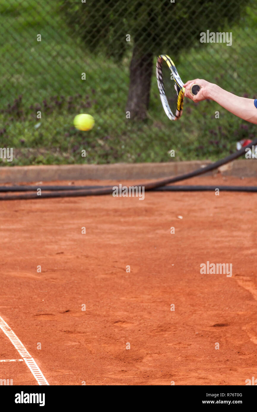 Human hand holding a tennis racket and preforming a forehand strike ...