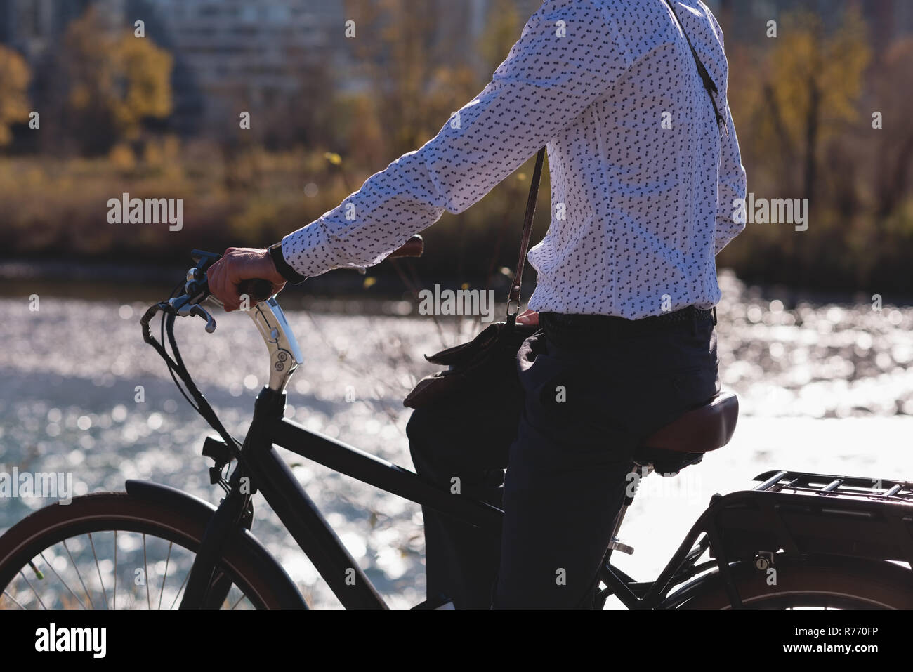 Man relaxing on a bicycle near riverside Stock Photo