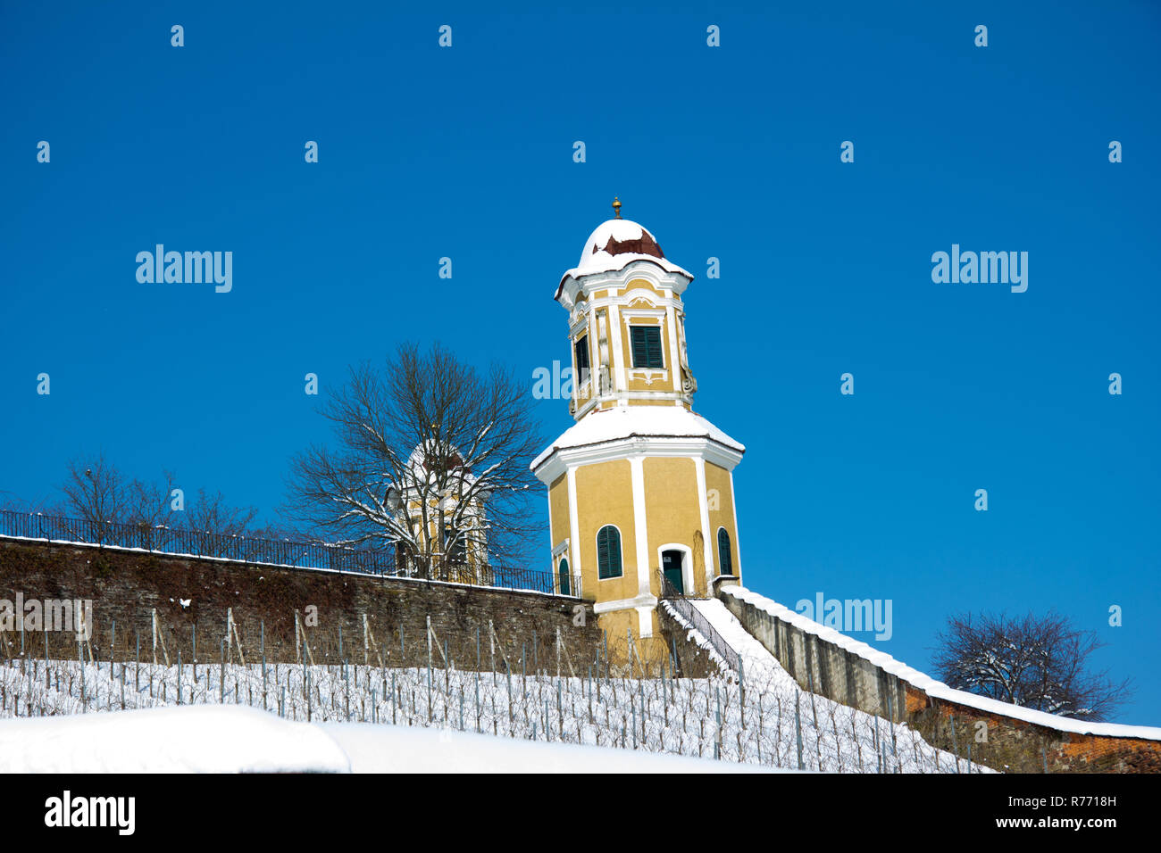 tower of baroque castle stainz partially covered with snow in front of blue sky in winter at day Stock Photo