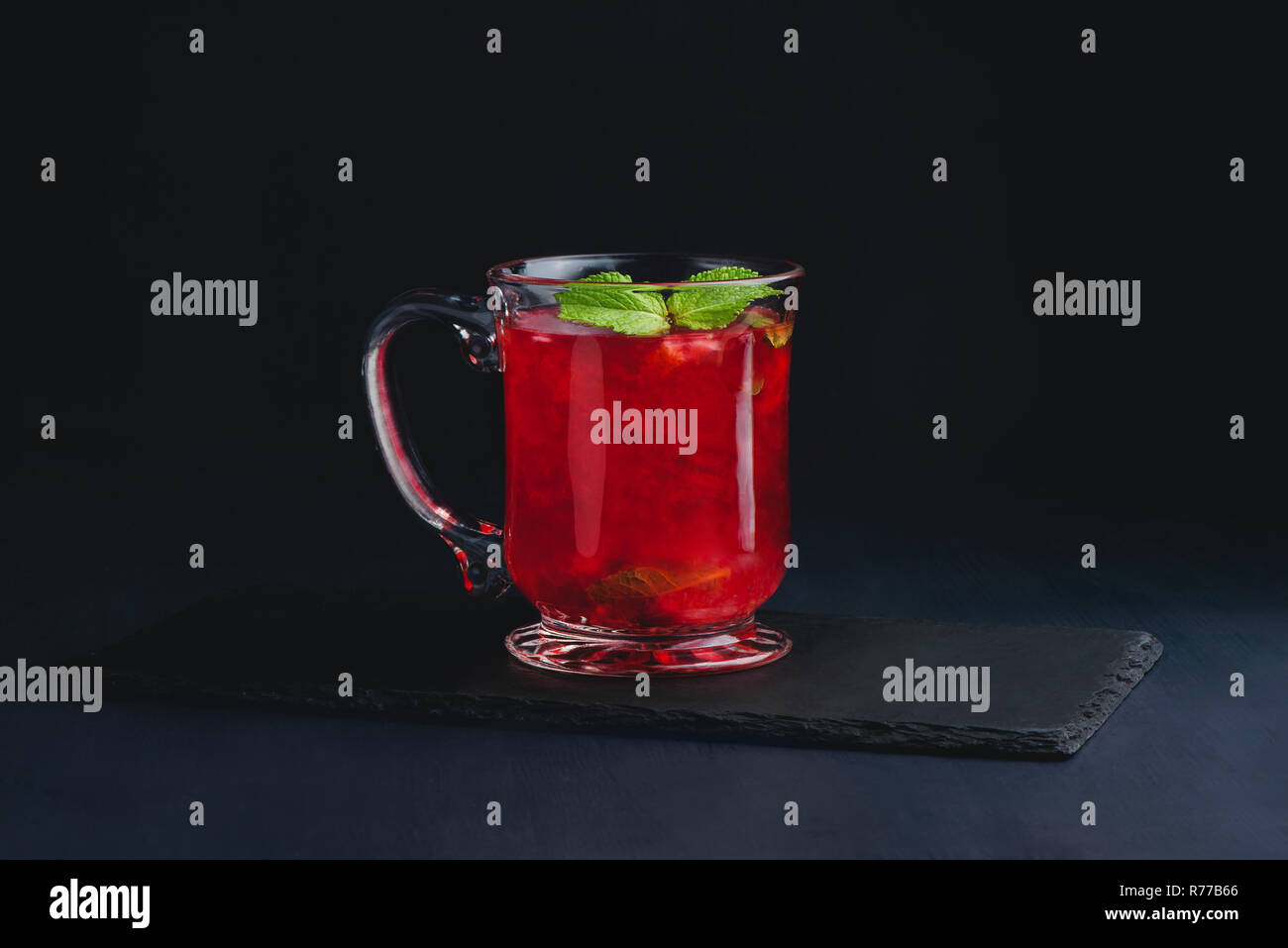 Fruit punch in a glass cup on a dark background with copy space for a menu. Strawberry, raspberry or cranberry winter drink Stock Photo