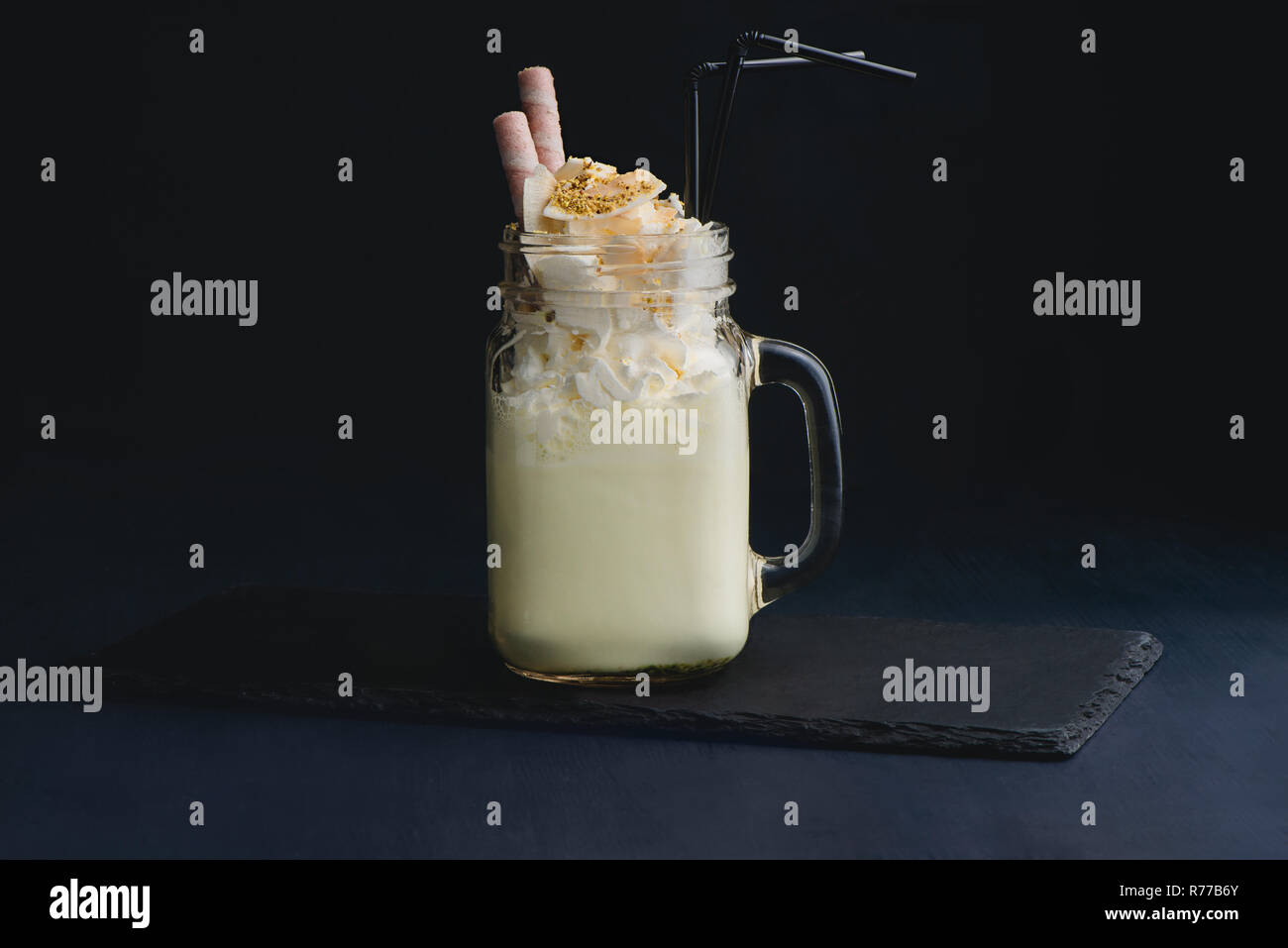 Vanilla Milkshake in Plastic Glass on a Dark Background. Vanilla