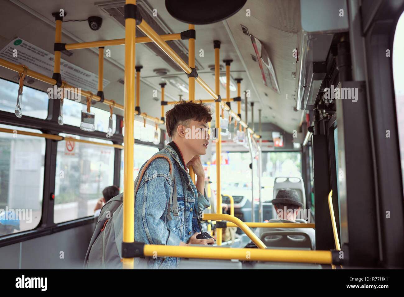 People, lifestyle, travel and public transport. Asian man standing inside city bus. Stock Photo