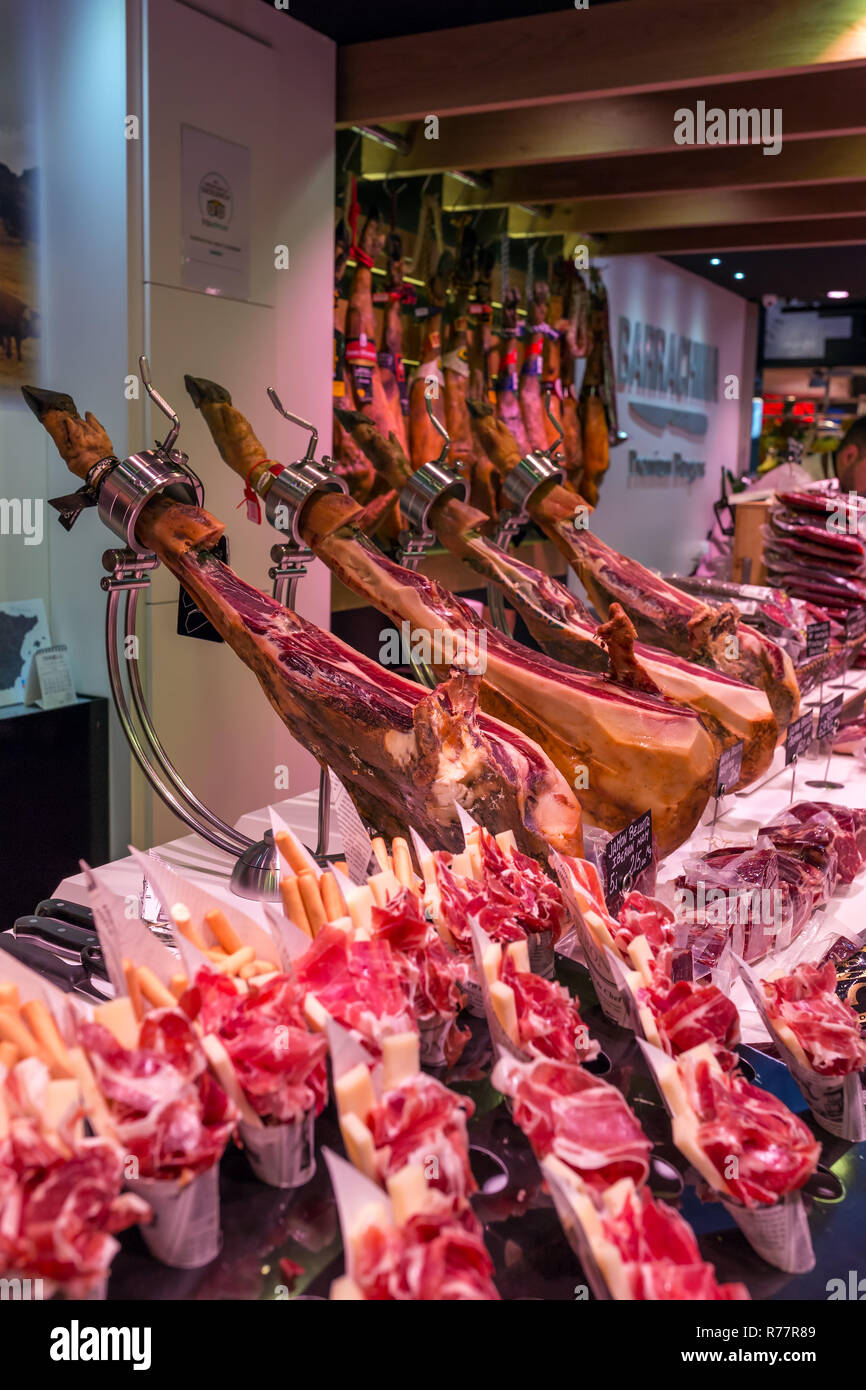 Spain, Barcelona - March 27, 2018: Boqueria market, jamon and sausages on the counter of the Spanish market Stock Photo