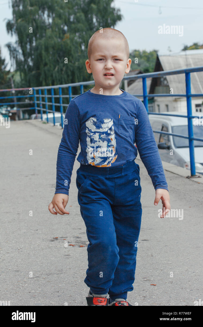 Portrait of cute smiling little boy in blue shirt, outdoor shot Stock