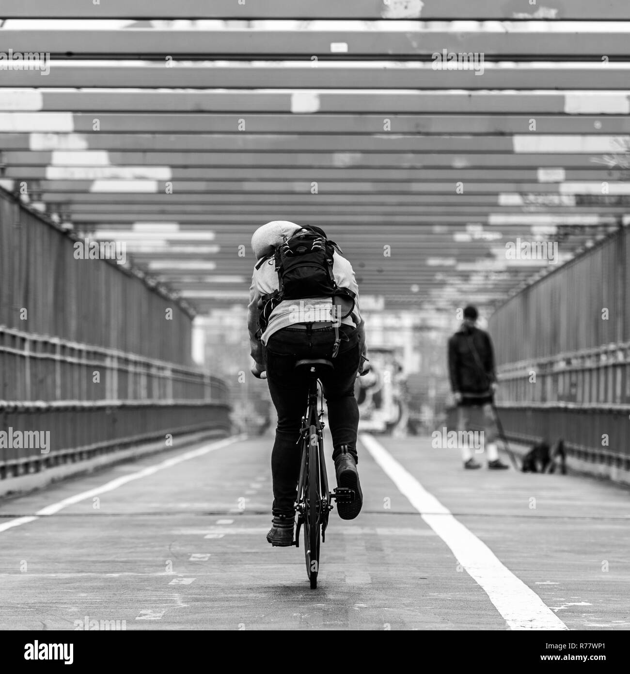Man riding his bike in the cycling lane on Williamsburg Bridge, Brooklyn, New York City. Stock Photo