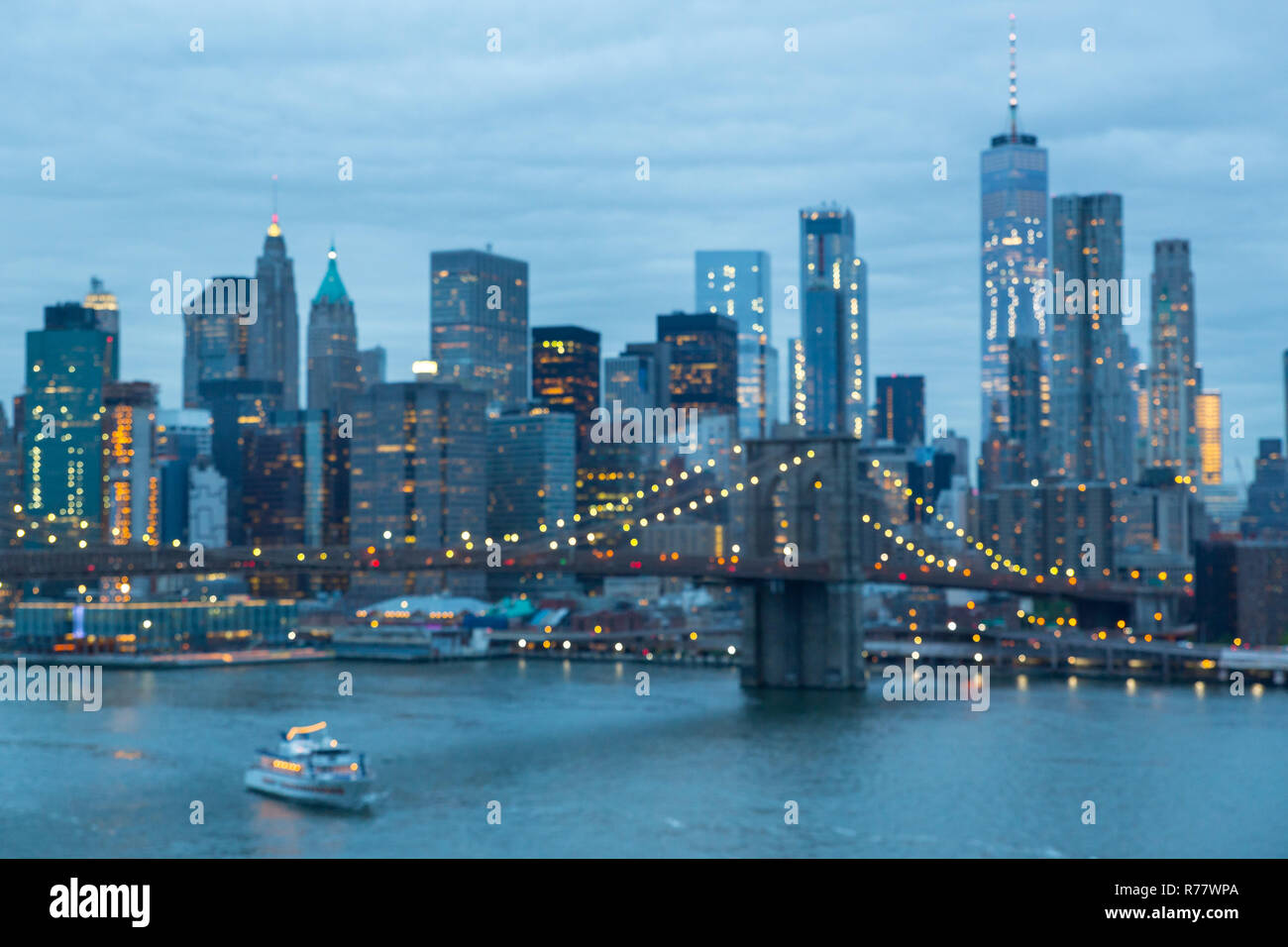 Out of focus image of Brooklyn Bridge and Lower Manhattan skyline at night, New York city, USA. Stock Photo