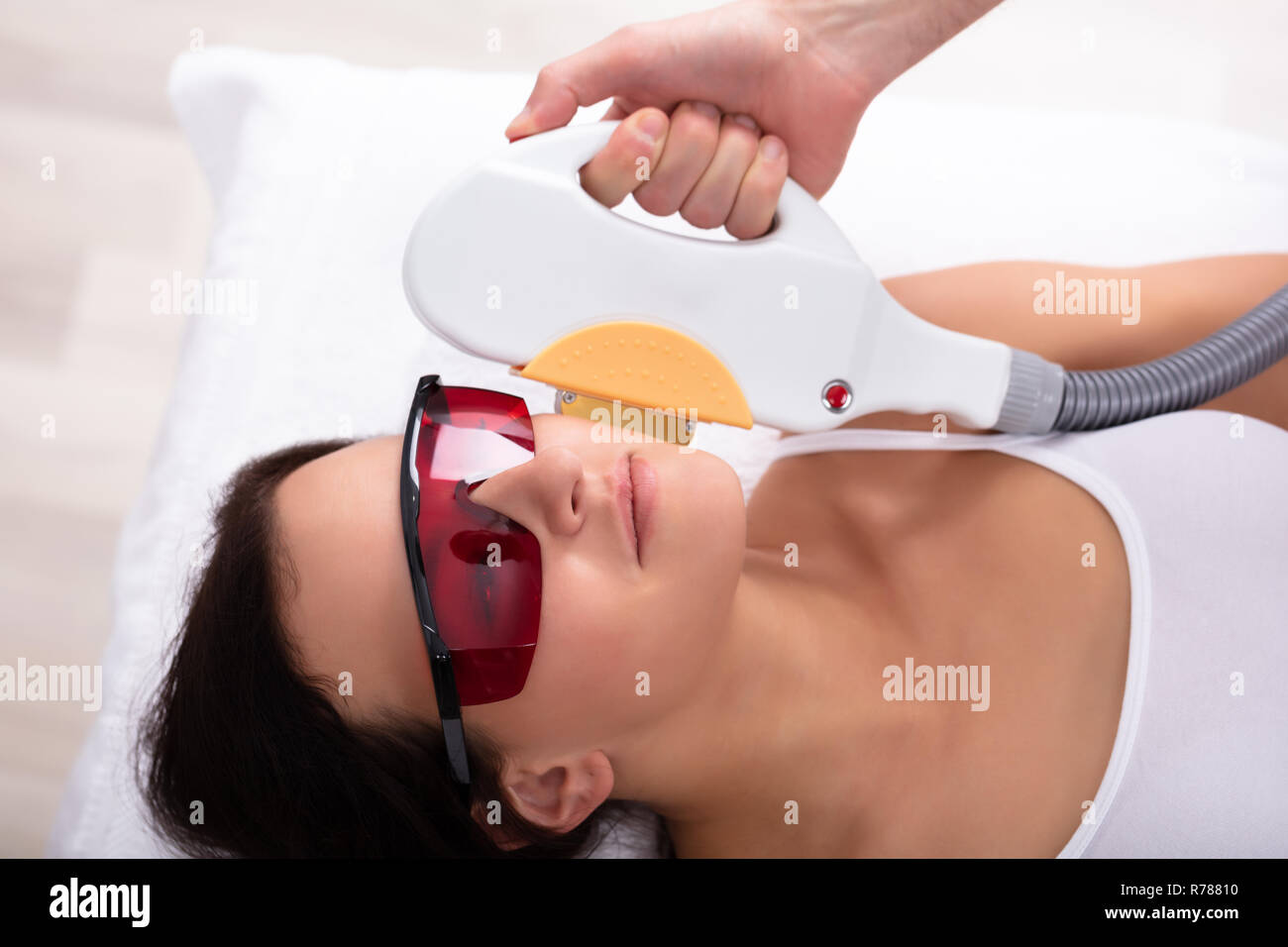 Close-up Of Beautician Hand Giving Laser Depilation Treatment To Young Woman Face Stock Photo