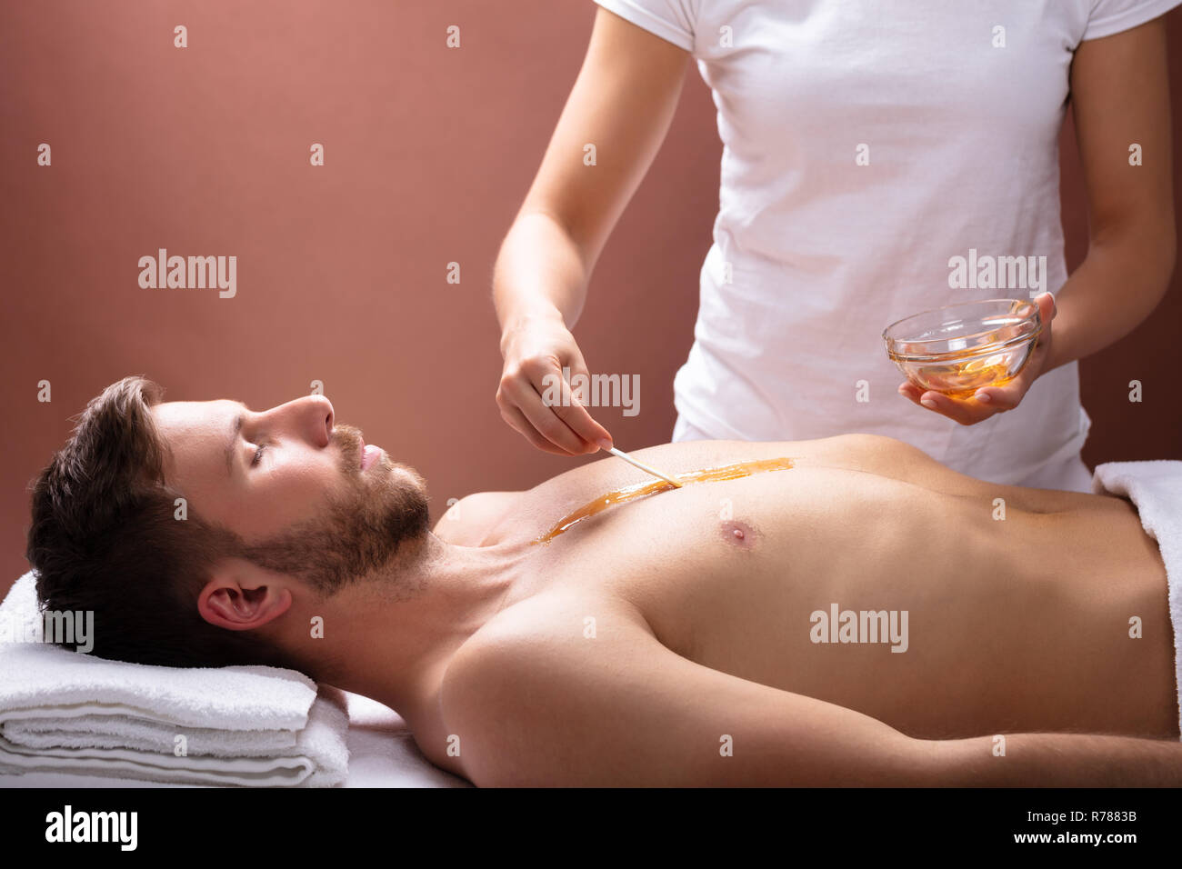 Close-up Of Therapist Hand Applying Wax On Relaxed Young Man's Chest Stock  Photo - Alamy