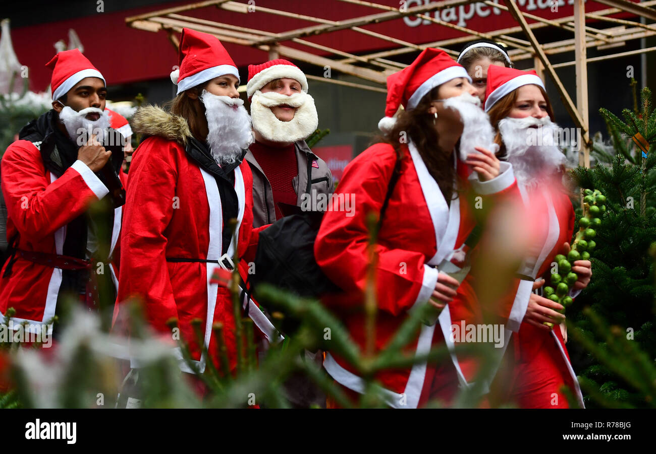 Participants dressed in Santa costumes make their way through the streets of London as they take part in Santacon London 2018. Stock Photo
